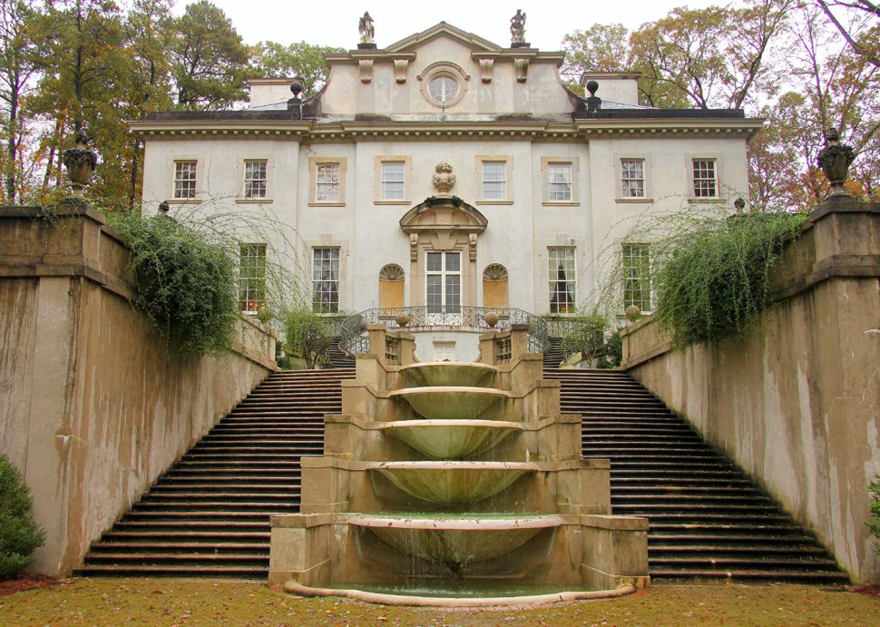 The Swan House exterior is featured in the background, with a cascading fountain, flanked by two staircases, leading up to the home’s entrance.