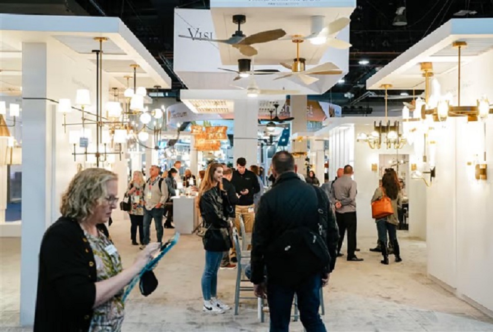 An image of people shopping around the NAHB International Building Show. There are a variety of light fixtures and ceiling fans around the room on display.